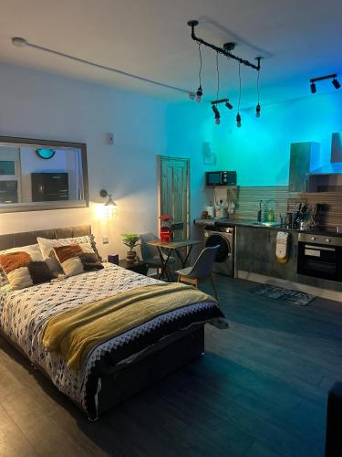 a bedroom with a bed and a kitchen at Luxury Industrial Studio Leeds Near Brudenell social club & Headingley Stadium in Headingley