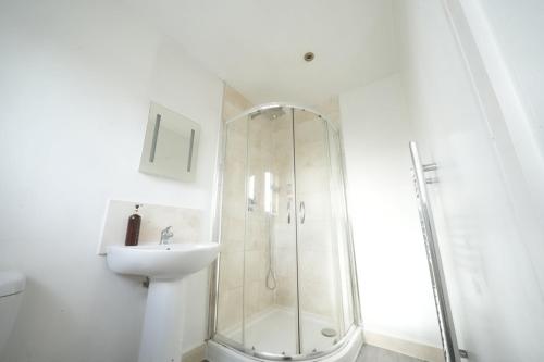 a white bathroom with a shower and a sink at Great Airport Sleep PRIVATE bathroom in all ROOMS in Harmondsworth