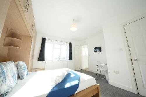 a bedroom with a large bed and a window at Great Airport Sleep PRIVATE bathroom in all ROOMS in Harmondsworth
