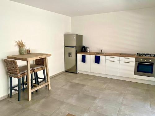 a kitchen with a table and a refrigerator at Kas Kalki Apartment in Willemstad