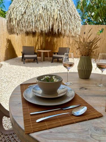 a table with a bowl of salad and glasses of wine at Kas Kalki Apartment in Willemstad