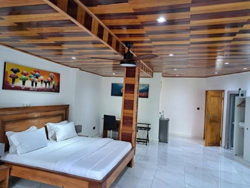 a bedroom with a bed and a wooden ceiling at Hôtel Restaurant Gites Kribi in Kribi