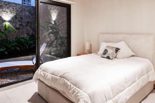 una camera da letto con un letto bianco con una grande finestra di Family pool and beach the perfect getaway a Bucerías