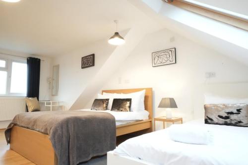 a bedroom with two beds in a attic at Great Airport Sleep PRIVATE bathroom in all ROOMS in Harmondsworth