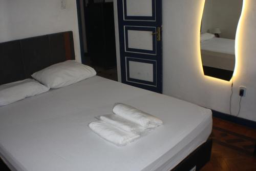 a bed with two folded towels on it in a room at Farfalla Guest House in Rio de Janeiro
