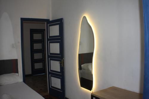 a room with a mirror and a surfboard on the wall at Farfalla Guest House in Rio de Janeiro
