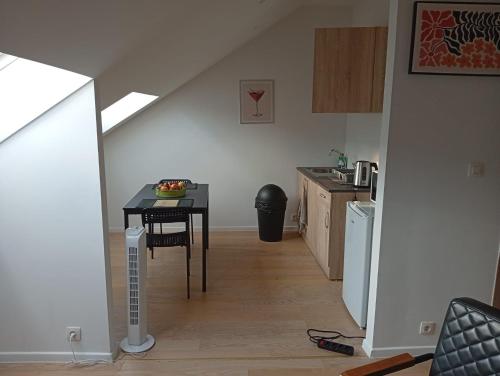 une cuisine avec une table et une petite table dans une pièce dans l'établissement studio supérieur, à Marcinelle