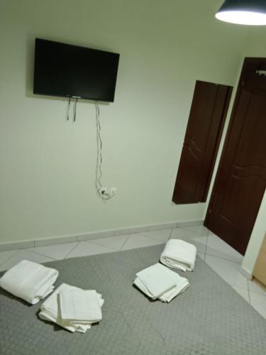 a room with two white towels and a flat screen tv at IRIS apartment in Sparti