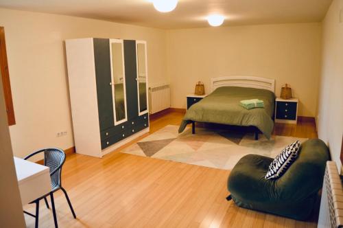 une chambre avec un lit et une chaise dedans dans l'établissement El Mirador de Jaca, à Araguás del Solano