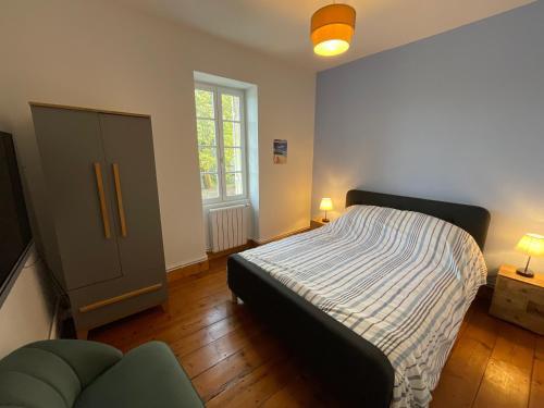 a bedroom with a bed and a couch and a window at MyQuinsac in Quinsac
