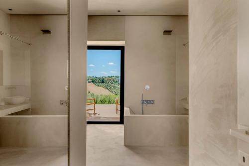 Una puerta pivotante se abre a un baño con vista. en OLIViA dimora, en Noto
