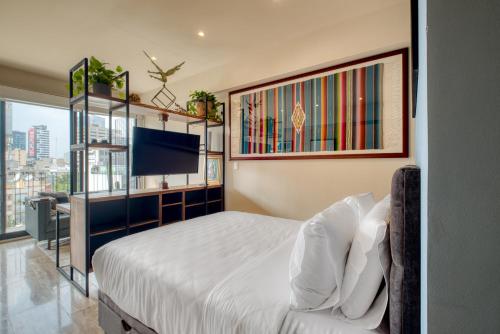 a bedroom with a bed and a flat screen tv at Myla Chapultepec in Mexico City