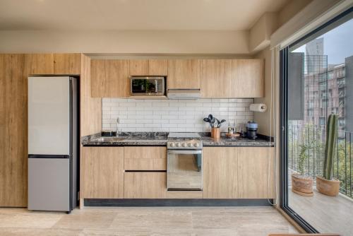 a kitchen with wooden cabinets and a white refrigerator at Myla Chapultepec in Mexico City