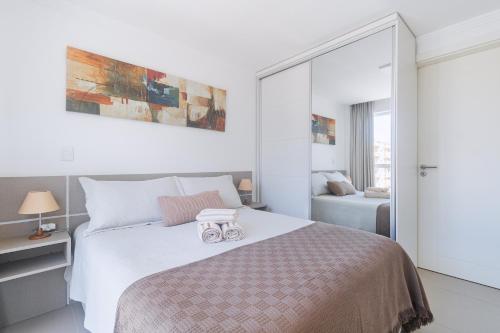 una camera da letto con un grande letto bianco con due paia di qualità di Apartamento Confortavel no Soul Flat, Centro de Torres a Torres