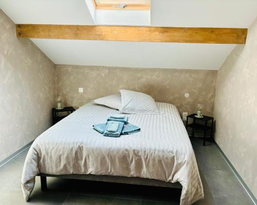 a bedroom with a bed with a blue jacket on it at Très joli logement in Anould
