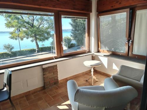 a living room with two chairs and two windows at Villa Marini in Trevignano Romano