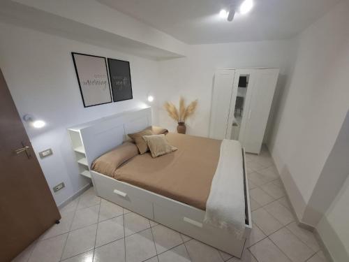 a bedroom with a large bed in a white room at SoLe Apartment in Campagnano di Roma