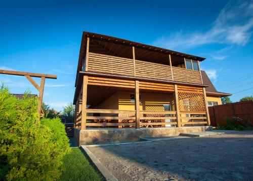 a wooden house with a gambrel roof at Fazenda in Sumy