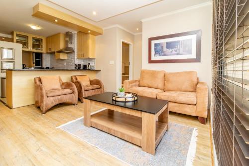 ein Wohnzimmer mit Sofa und Tisch in der Unterkunft Opulent Heights - Katherine Quay Sandton in Johannesburg