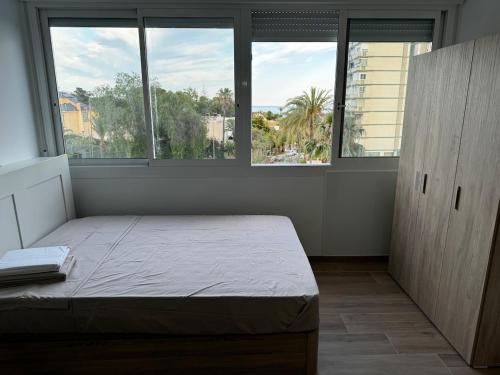 a bedroom with a bed in a room with windows at Studio 200 m from the sea in Aguadulce