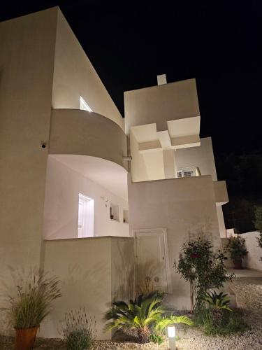 a large white building with plants in front of it at Maruzza Home in Favignana