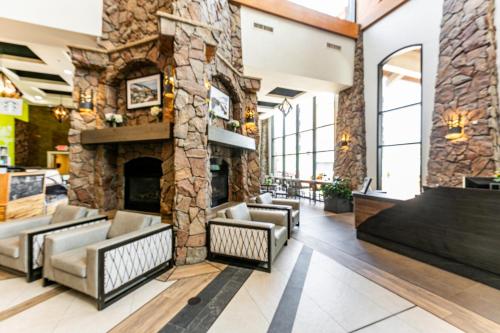 a lobby with couches and a stone fireplace at Condos at Canyons Resort by White Pines in Park City