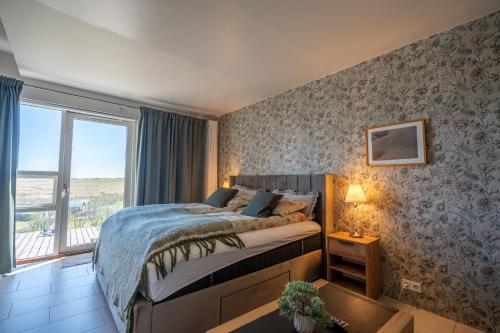 a bedroom with a bed and a large window at Hotel Laki in Kirkjubæjarklaustur