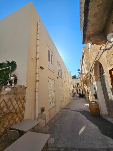 an alley with tables and chairs in a building at Maruzza Home in Favignana