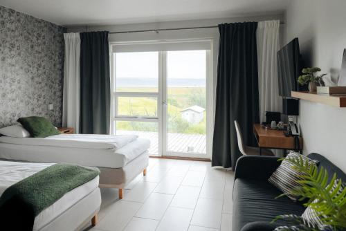 a hotel room with two beds and a large window at Hotel Laki in Kirkjubæjarklaustur