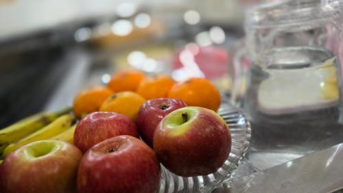 a glass bowl of apples and bananas and oranges at Hotel Terra do Sal in Mossoró