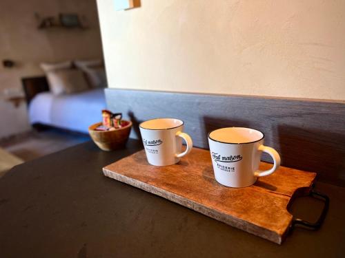 two coffee mugs sitting on a wooden tray on a table at Haut Charmes de Cornil in Cornil