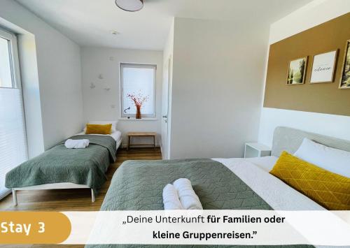 Un dormitorio con dos camas y una ventana. en Stay zentrale Schwarzwald Apartments, en Nagold
