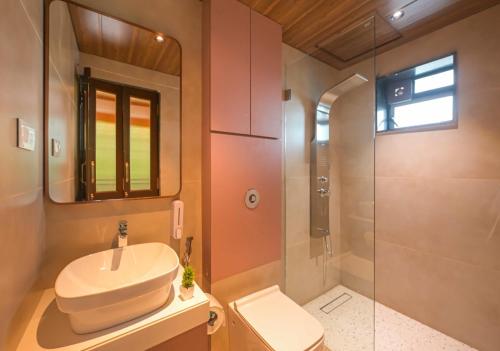 a bathroom with a sink and a toilet and a shower at 5BHK Villa With Pool & Theater Room in Malavli