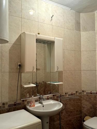a bathroom with a sink and a mirror at Serana Stays Classic Apartment with Private Bathroom, Free WiFi & Parking, Central Pejë in Peje
