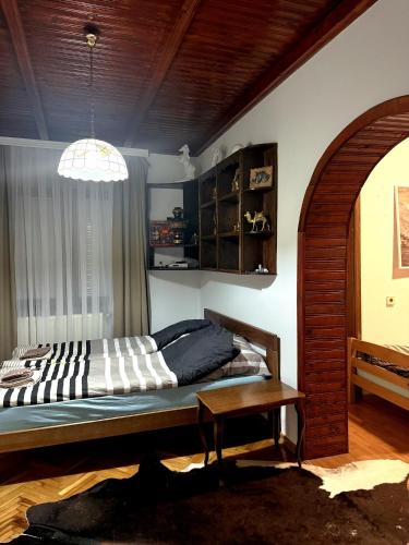 a bedroom with a bed and a table at Serana Stays Classic Apartment with Private Bathroom, Free WiFi & Parking, Central Pejë in Peje