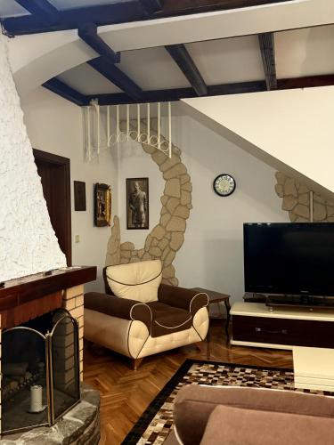 a living room with a fireplace and a tv at Serana Stays in Peje