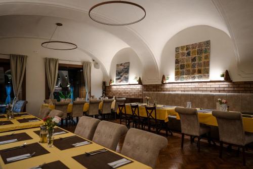 a dining room with long tables and chairs at Hotel Arkada in Levoča