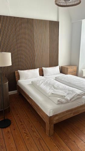 リューベックにあるOstsee Hotel Lübeckのウッドフロアのベッドルーム1室(ベッド1台付)