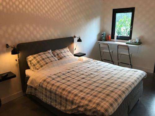a bedroom with a bed and a table and a window at Bij Zelle in Garderen