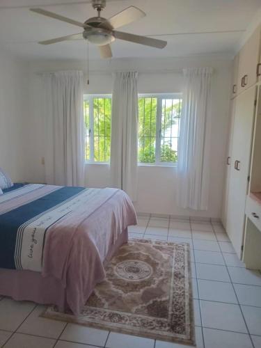 a bedroom with a bed and a ceiling fan at Vervet Guesthouse in Port Edward