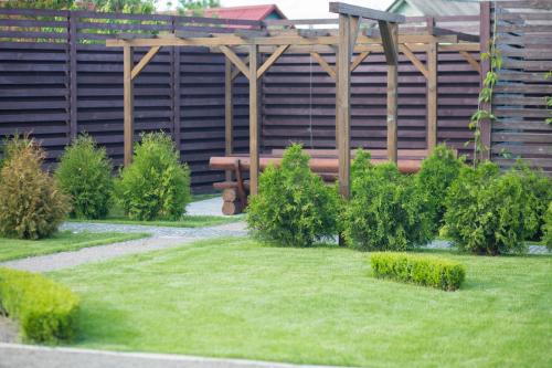 a garden with a wooden bench in front of a building at Fazenda in Sumy