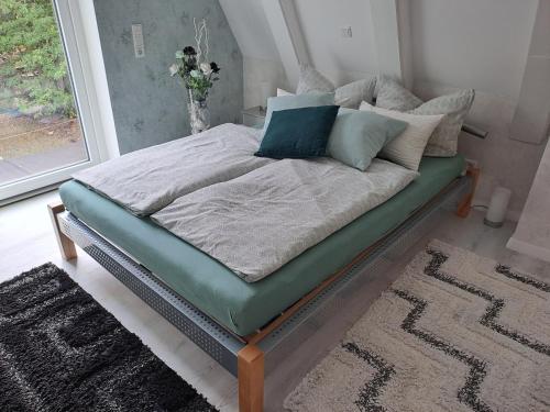 a bed with pillows on it in a room with a window at DESIGN-LOFT Brockenblick in Wernigerode