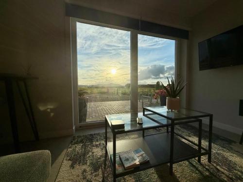 a living room with a glass table and a large window at Star Scape in Markinch
