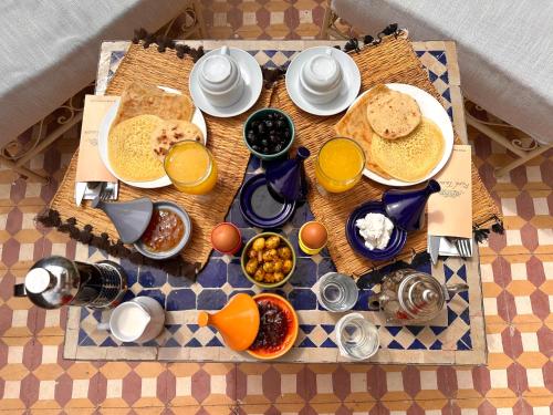 a breakfast table with breakfast foods on a checkered table cloth at Riad Tasneem in Marrakech