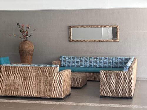 a living room with two wicker couches and a mirror at Relax en Ricaurte, Jacuzzi privado, 94 Mts in San Rafael