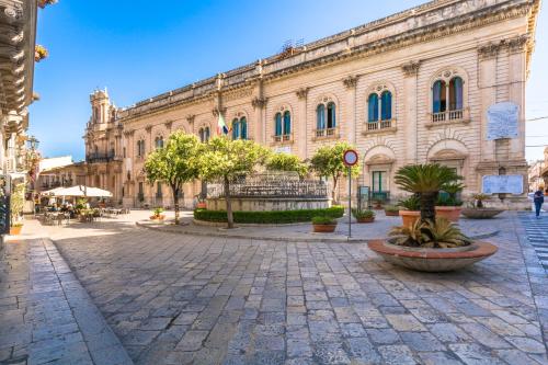 a large building with a plaza in front of it at Scicli Albergo Diffuso in Scicli