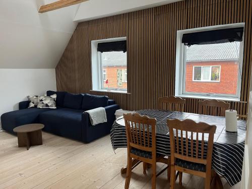 a living room with a blue couch and a table at Lejlighed med højt til loftet in Herning
