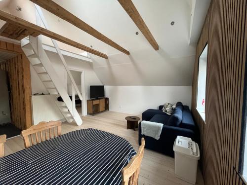 a bedroom with a blue bed and a staircase at Lejlighed med højt til loftet in Herning