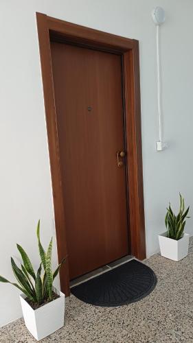a door with two potted plants in front of it at Salso Experience apartment in Salsomaggiore Terme