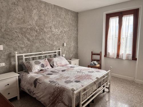 プラートにあるSotto il Vaporeの白いベッドと窓のある寝室